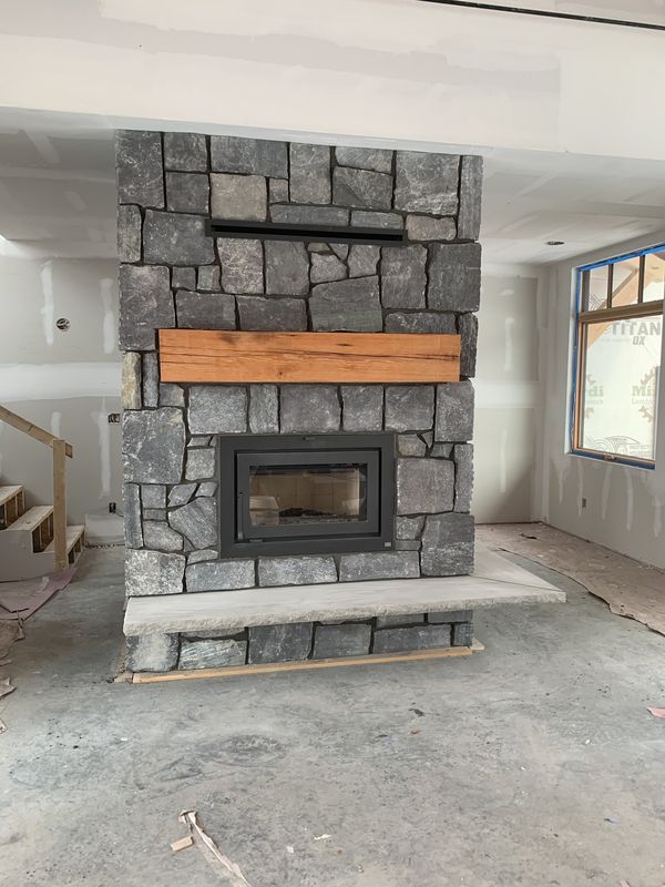 Custom stone fireplace with wood mantel